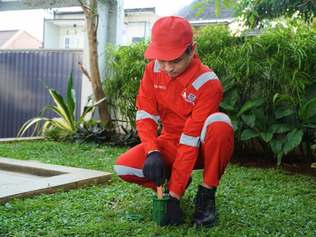Teknisi Petrokil sedang memasang stasiun umpan rayap sebagai bagian dari layanan jasa basmi rayap profesional di area rumah pelanggan.